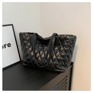 Detail of black quilted tote bag with large capacity and elegant stitched pattern