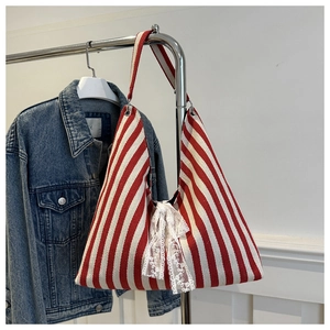 Close-up of red and white striped canvas tote bag with a white lace bow detail
