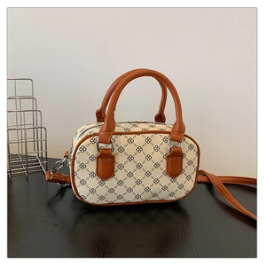 Detailed macro view of vintage print mini Boston bag with brown leather handles and hardware