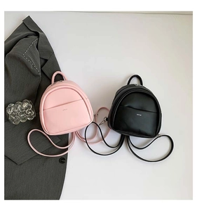 Détail de mini sacs à dos en cuir rose et noir avec une poignée supérieure chic