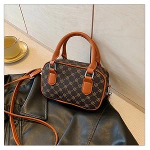 Detail of vintage Boston bag with gold interlocking print and brown leather handles