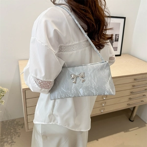 Sac hobo argenté plissé avec nœud métallique pour femme porté à l'épaule