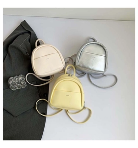 Trois mini sacs à dos élégants en cuir beige, argent et jaune présentés à plat