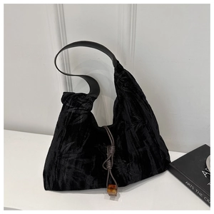 Détail du sac cabas en velours noir avec texture bambou et perle ambrée décorative