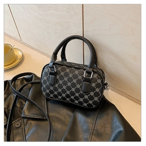 Detail of Boston-style mini handbag with white chain print on black textured leather