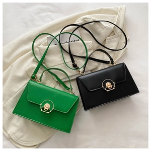 Detail of trendy crossbody bag with metallic circular lock and adjustable strap