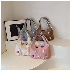 Detail of soft fabric tote bags with colorful heart patches and silver metallic handles