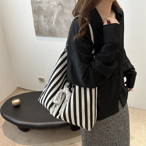 Chic black and white striped canvas tote bag with a white lace bow for casual daily wear
