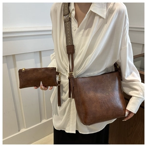 Detail view of brown vintage PU leather bucket bag set with patterned wide strap