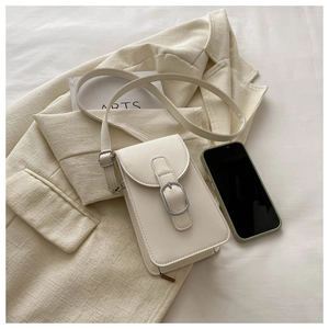 Close-up of minimalist cream leather phone crossbody bag with silver buckle and shoulder strap