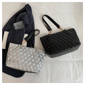 Close-up of quilted tote bags in silver and black with elegant chain shoulder straps