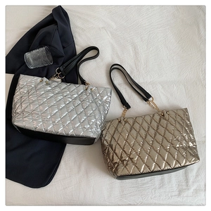 Detail of silver and champagne gold quilted tote bags with metallic finish and chain straps