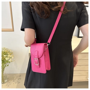 Detail of fuchsia PU leather mini crossbody phone bag with silver buckle and shoulder strap