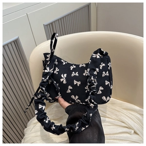 Dettaglio della borsa a spalla in nylon a fiori con fiocchi e bordi a volant