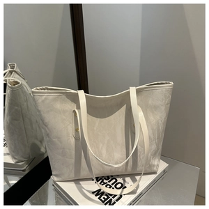 Detailed view of the off-white tote bag featuring a unique marble texture and slim straps