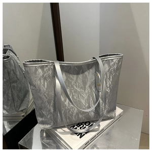 Detail of silver metallic tote bag with unique crinkled texture and sleek shoulder straps
