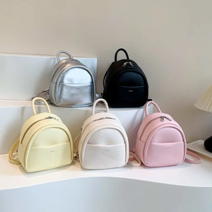 Mini sacs à dos en similicuir en argent, noir, jaune, blanc et rose sur des podiums