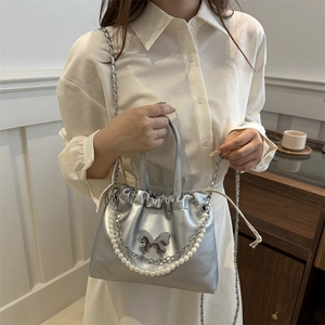 Sac à main argenté métallisé avec fermoir papillon et bandoulière en chaîne de perles