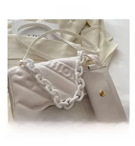 Detail view of white quilted crossbody bag with resin chain and mini coin pouch