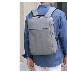 Uomo con zaino porta PC grigio da lavoro con porta USB laterale in ambiente esterno
