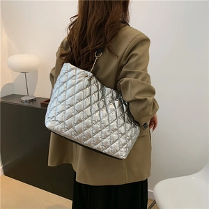 Silver quilted tote bag with large capacity and rhombic pattern worn on shoulder