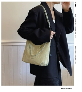 Détail du sac fourre-tout vert clair avec texture plissée brillante et chaîne