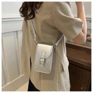 Side view of a silver minimalist crossbody mobile phone bag worn by a model