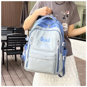 Detail eines Canvas-Rucksacks mit Farblock-Design und SÜLÚ-Schriftzug in einer Alltagsszene