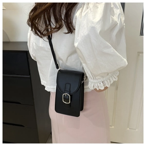 Vertical black crossbody phone bag shown on a model with silver buckle and slim strap