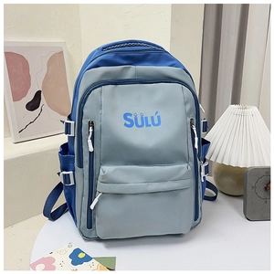 Detailansicht des blau-grauen Rucksacks mit SÜLÜ-Logo in einer Schreibtischumgebung