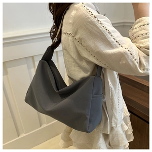 Deep grey nylon tote bag side view with soft drape design on female model for commuting
