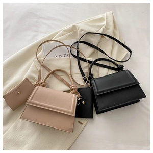Detail of minimalist shoulder bags with knot handle design and mini purse accessory