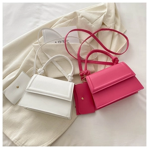 Detail view of stylish trapezoid crossbody bags in white and rose pink with mini card pouches