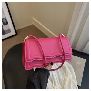Dettaglio della borsa a tracolla rosa con bordo a onde e finitura in ecopelle elegante
