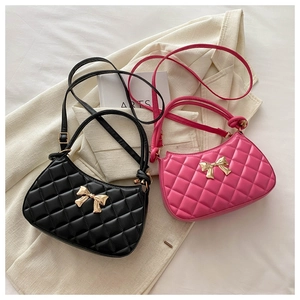 Détail de sacs à bandoulière matelassés rose et noir avec boucles métalliques dorées