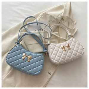 Détail des sacs à main croissants matelassés avec élégants nœuds dorés en métal