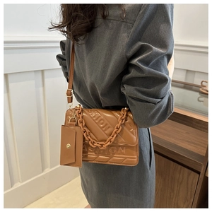 Detail of caramel quilted square crossbody bag with chain strap and small card holder