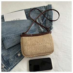 Detailed top view of a rectangular straw woven crossbody bag with brown leather strap