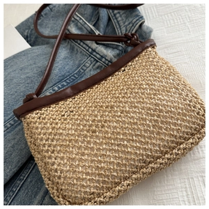 Top view of handmade straw crossbody bag with brown leather strap and knot details
