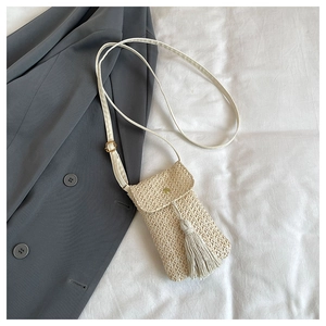 Detailed straw weave texture on beige crossbody phone bag with tassel and gold magnetic buckle