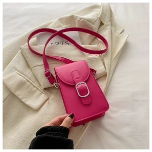 Detailed macro view of fuchsia leather phone bag featuring silver buckle and fine texture