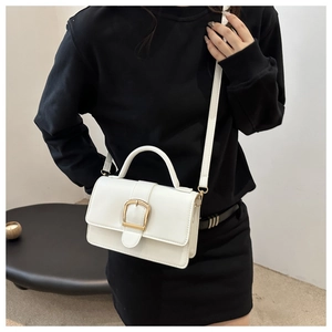 Détails du sac à main blanc minimaliste avec boucle dorée et poignée supérieure en cuir