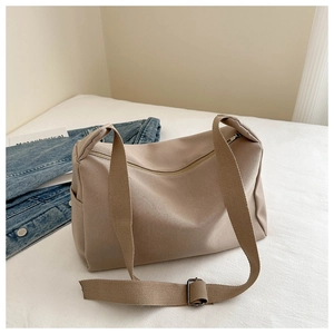 Detail of khaki nylon shoulder bag featuring side pocket and adjustable wide strap