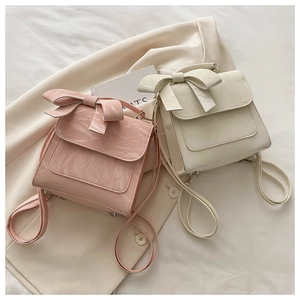 Detail of pink and beige bow backpacks with marble texture leather in a cozy setting