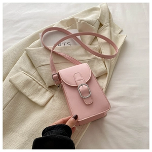 Detail of pink vertical crossbody phone bag with silver buckle on a beige blazer