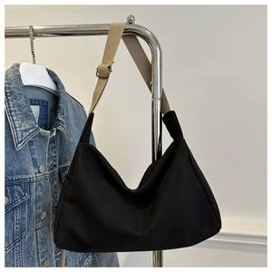 Detail of minimalist black nylon tote bag with khaki wide strap and silver metal buckle