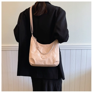 Détail d'un sac cabas rose pâle avec texture marbrée et chaîne en argent chic