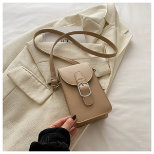 Detail view of khaki crossbody phone bag with silver square buckle on suit jacket