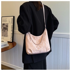 Détail de la texture en cuir plissé rose clair avec chaîne argentée du cabas