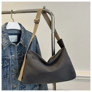 Detail view of charcoal gray nylon bag featuring a durable khaki adjustable shoulder strap